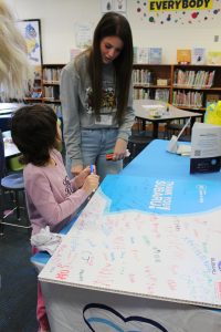 Photo of child signing event poster