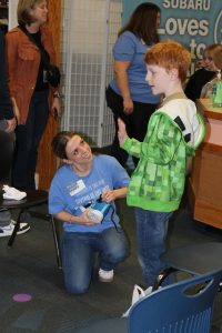 Photo of volunteer fitting child with new shoes