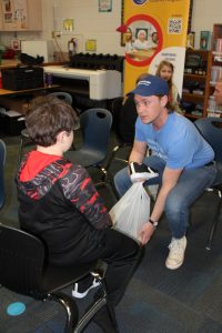 Photo of volunteer fitting child with new shoes