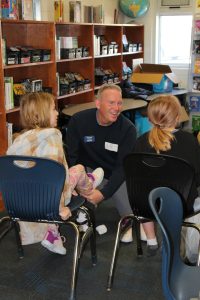 Photo of volunteer fitting child with new shoes