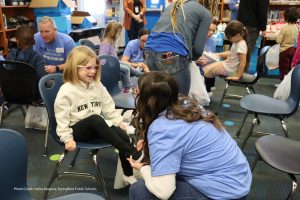 Photo of volunteer fitting child with new shoes