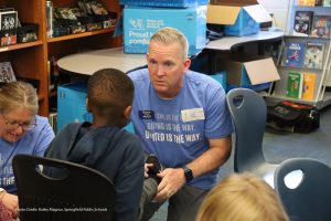 Photo of volunteer fitting child with new shoes