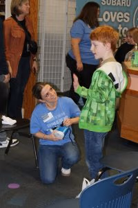 Photo of volunteer fitting child with new shoes