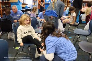 Photo of volunteer fitting child with new shoes