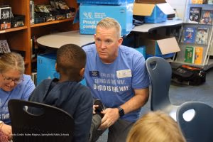 Photo of volunteer fitting child with new shoes